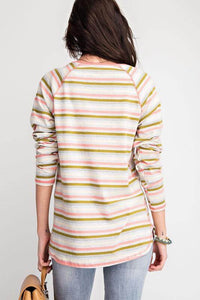 Woman wearing colorful pink-green-gray striped long sleeve top back.