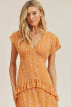 Close-up of floral print and waistline details on orange dress
