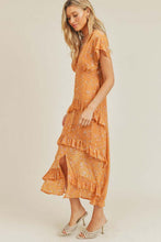 Model twirling in orange ruffle midi dress outdoors