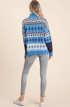 Women wearing a blue and white knitted sweater with diamond and heart pattern back.