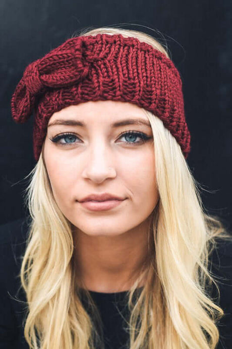 Blond woman wearing dark red knitted headband with bow