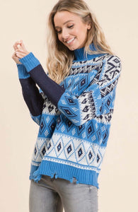 Women wearing a blue and white knitted sweater with diamond and heart pattern side.