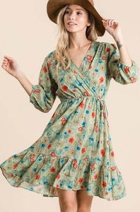 Lightweight green mini dress with all over colorful floral print with adjustable tied waist and v neck front