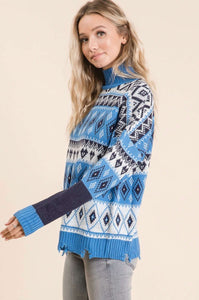 Women wearing a blue and white knitted sweater with diamond and heart pattern side.