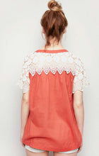Women's orange lightweight top with lace up front and cream lace sleeves back.