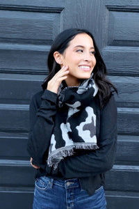 Woman wearing black and grey Camo design panache scarf with frayed detail front.