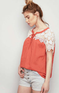 Women's orange lightweight top with lace up front and cream lace sleeves side.