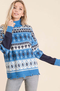 Women wearing a blue and white knit sweater with diamond and heart pattern front.
