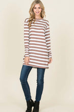 Woman wearing soft hip length brown and white stripped long sleeve crew neck shirt front. 