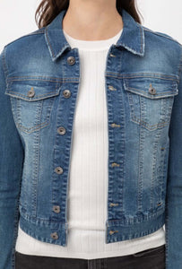 Woman wearing long sleeve button up front closure waist length blue jean denim jacket front.