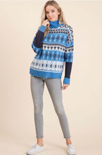 Women wearing a blue and white knitted sweater with diamond and heart pattern front.