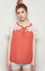 Women's orange lightweight top with lace up front and cream lace sleeves front.