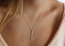 Woman wearing an elegant bar pendant on an 18" chain costume jewelry necklace front.