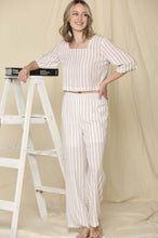 Woman wearing two piece brown and cream stripe crop top shirt and wide leg trouser pants  set front.