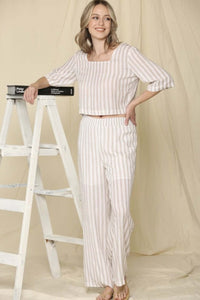 Woman wearing two piece brown and cream stripe crop top shirt and wide leg trouser pants  set front.