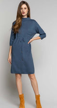 Women's blue sweater minidress with mock neckline, front pocket, and tie front detail front.