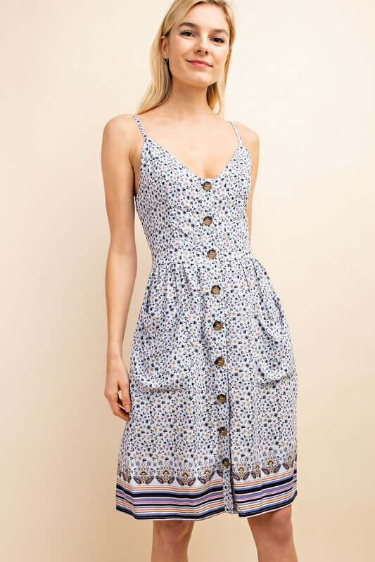Woman waring blue floral adjustable sleeveless slip dress with wood style button front closure front.