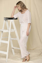 Woman wearing two piece brown and cream stripe crop top shirt and wide leg trouser pants  set side.